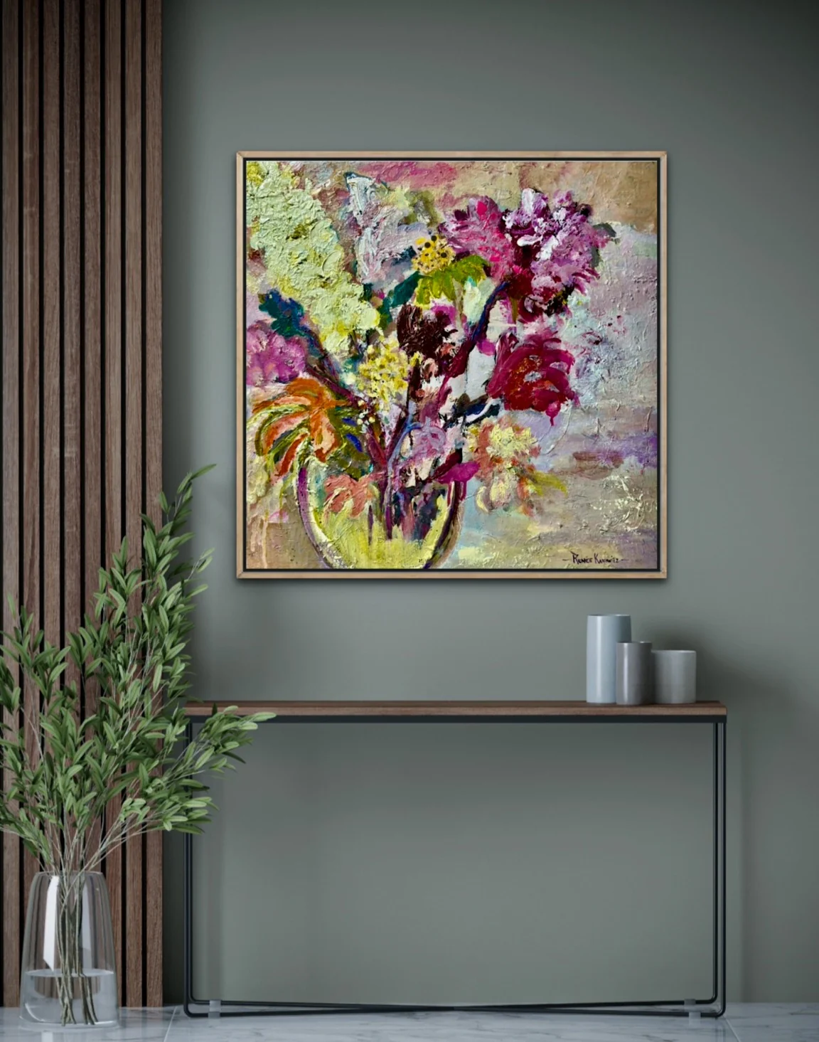 A framed floral painting by Renée Kanowitz hanging above a console table